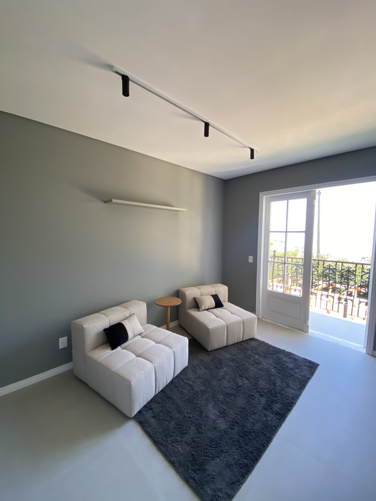 Living contemporâneo com varanda do casarão ao fundo